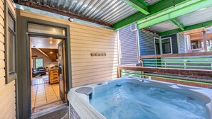 A spa area with a hot tub, wooden flooring, and a covered patio. - Old Town Ski House, Walk to Park City Mountain, Private Hot Tub, AC (Park City)