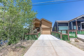 A residential area with a paved driveway leading to a house with a garage.