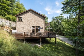 Ein Steinhaus mit einer Terrasse und Sitzgelegenheiten im Freien.