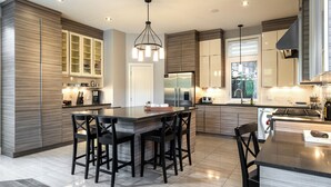Una cocina moderna con una isla central, armarios empotrados y un amplio ventanal.