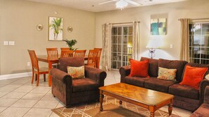 A living room with a dining area, two sofas, a coffee table, and a ceiling fan. - Cherry Grove Villas 204, Golf Villa Bliss near Ocean (North Myrtle Beach)
