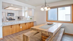 Una cocina moderna con armarios blancos, encimera de granito y una isla de madera.
