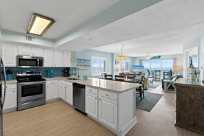 Una cocina moderna con armarios blancos, una estufa de acero inoxidable y un lavavajillas.