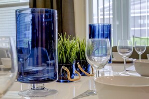 A table set with clear glassware and a small potted plant.