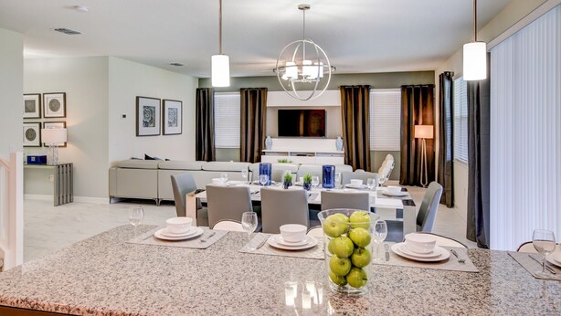 Une chambre d’hôtel moderne dotée d’un coin repas, d’un canapé et d’une télévision.