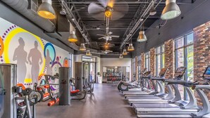 A gym with treadmills, weight machines, and a mural on the wall. - Value & space for everyone! Free Resort Amenities | Pool, Mini-Golf, Sand Volleyball | Sleeps 12 (Davenport)