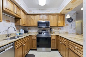 Kitchen features a Bosch dishwasher, microwave, and black oven, along with a granite countertop and stainless steel range hood.