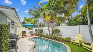 Ein Garten mit Pool, Grill und Gartenmöbeln.