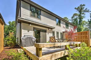 Enjoy outdoor dining and socializing on the covered deck with a grill, table, and chairs.