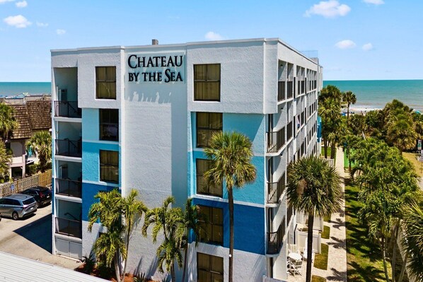 Un hôtel à plusieurs étages, appelé « Château au bord de la mer », offrant une vue sur l’océan.