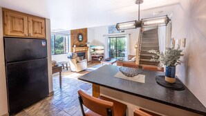 A spacious kitchen with a large island, wooden cabinets, and a black refrigerator. - Canyons Resort 2BR | 2-Mins to Cabriolet | Free On-Call Shuttle | Hot Tubs | Updated Redpine Condo (Park City)