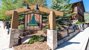 A wooden sign with a pine tree logo and the words "Redpine Clubhouse". - Canyons Resort 2BR | 2-Mins to Cabriolet | Free On-Call Shuttle | Hot Tubs | Updated Redpine Condo (Park City)