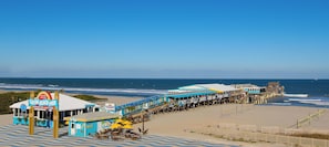 A beach pier with a restaurant named Cocoa Beach Pier, featuring outdoor seating and a view of the ocean.