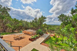 Un espacio patio al aire libre con un conjunto de asientos, jardineras y vistas del paisaje circundante.