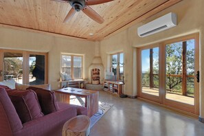 Un amplio salón con techo de madera, ventanas grandes y vistas al exterior.