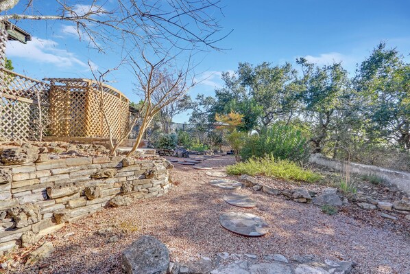 A garden pathway with stone steps and a wooden fence.