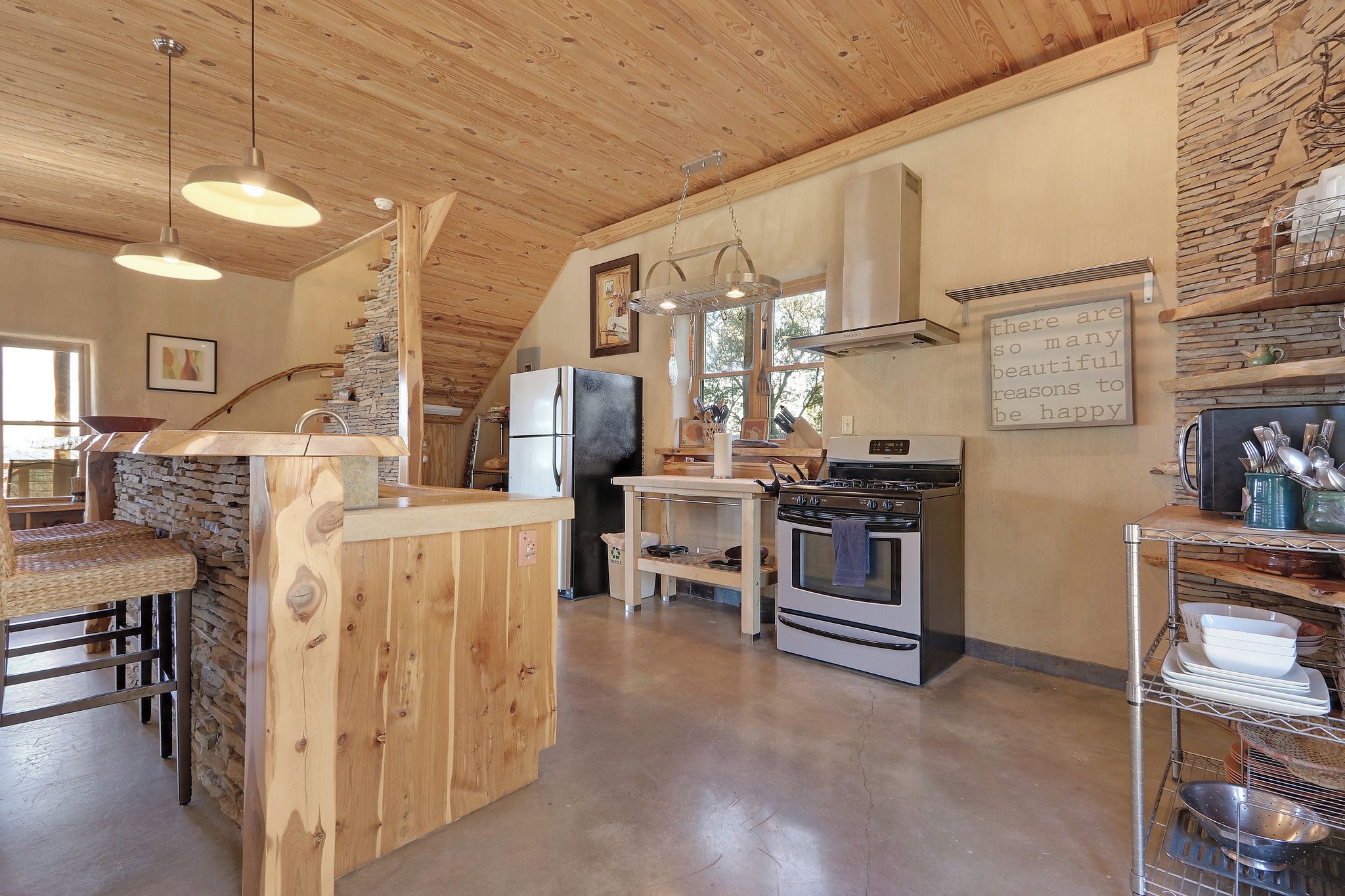 Una cocina rústica con una isla de madera, una estufa y un refrigerador.