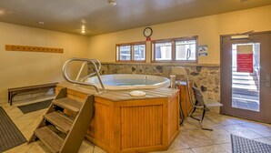 A wooden hot tub with steps, a clock, and a caution sign about icy conditions.