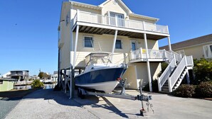 A two-story house with a boat on a trailer in front.