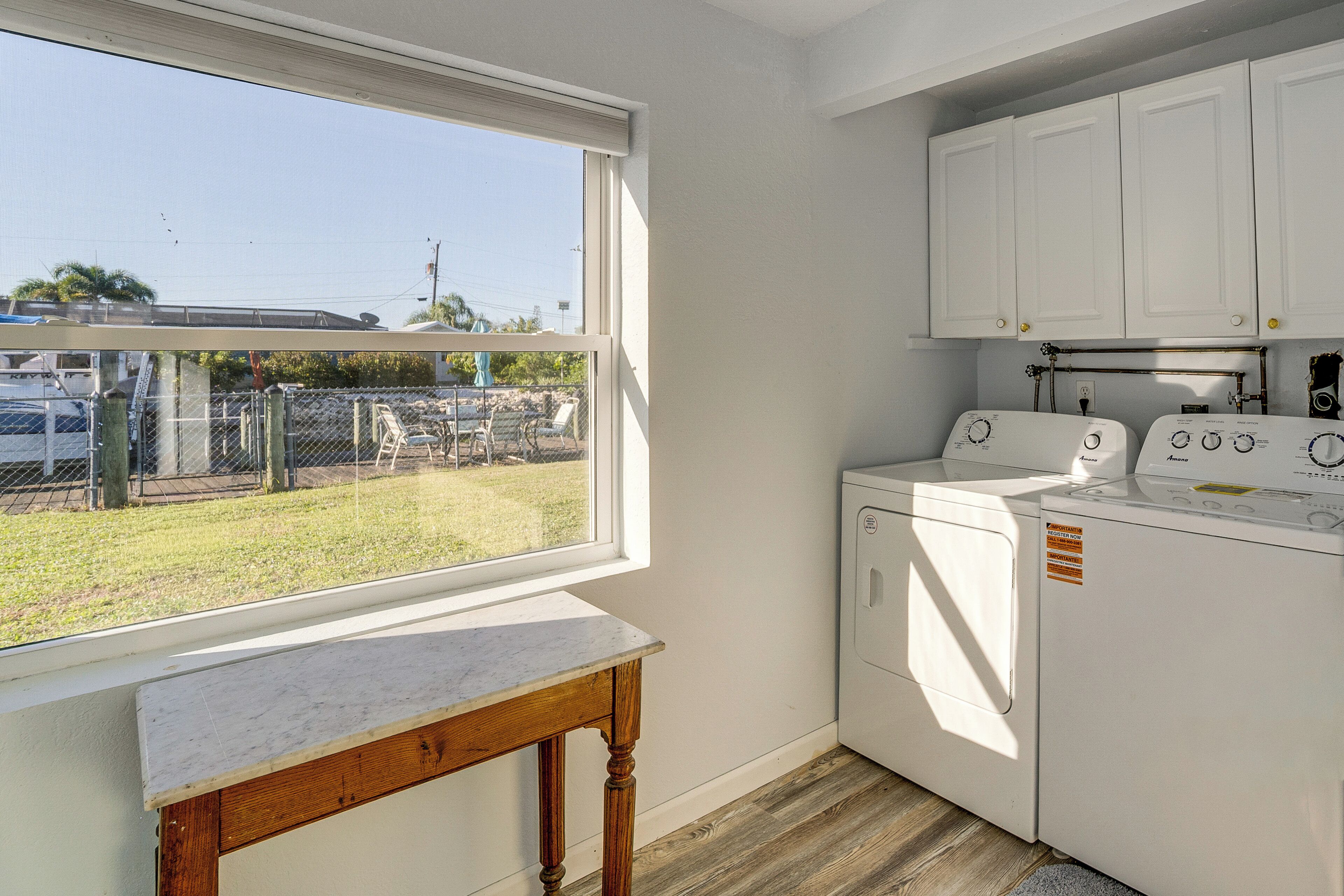 Una lavandería con lavadora, secadora y una mesa.