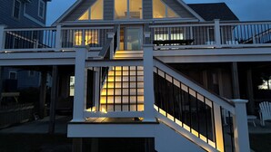 Een tweelaags huis met een balkon, een trap en een groot raam.