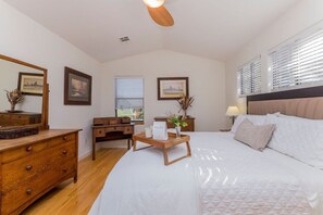A bedroom with a bed, dresser, bedside table, lamp, and framed pictures on the walls. - SoCo steps away + screened porch, artsy vibe (Austin)