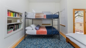 A bunk bed room with a bookshelf, a window with blinds, and a door leading outside. - SoCo steps away + screened porch, artsy vibe (Austin)