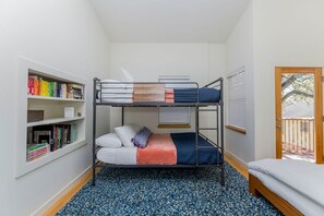 A bunk bed room with a bookshelf, a window with blinds, and a door leading outside. - SoCo steps away + screened porch, artsy vibe (Austin)