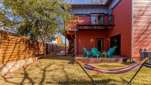 A red building with a balcony, a hammock, and outdoor seating. - SoCo steps away + screened porch, artsy vibe (Austin)