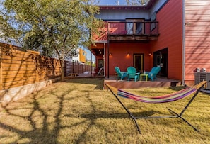 A red building with a balcony, outdoor seating, and a hammock. - SoCo steps away + screened porch, artsy vibe (Austin)