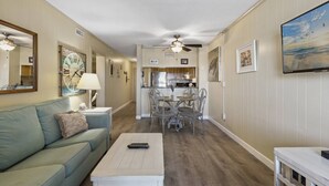 A living room with a sofa, coffee table, and a dining area with chairs and a table. - *Fall into Savings-20% Off New Bookings thru 2026* (Garden City)
