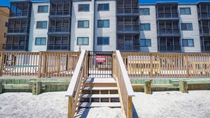 A multi-story residential building with balconies, a wooden deck, and a swimming pool sign. - *Fall into Savings-20% Off New Bookings thru 2026* (Garden City)