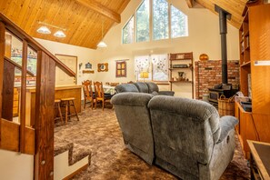 Relax in this inviting living area with a comfortable sofa, dining table, and brick fireplace.