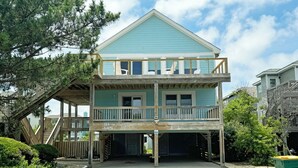 A two-story beachfront house with a balcony, wooden deck, and a covered entryway. - OS628- 4 Br. Oceanside with Pool, Hot tub, and Short walk to beach! (Corolla)