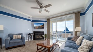 Un salon comprenant un canapé, une table basse, une cheminée et un balcon avec vue.