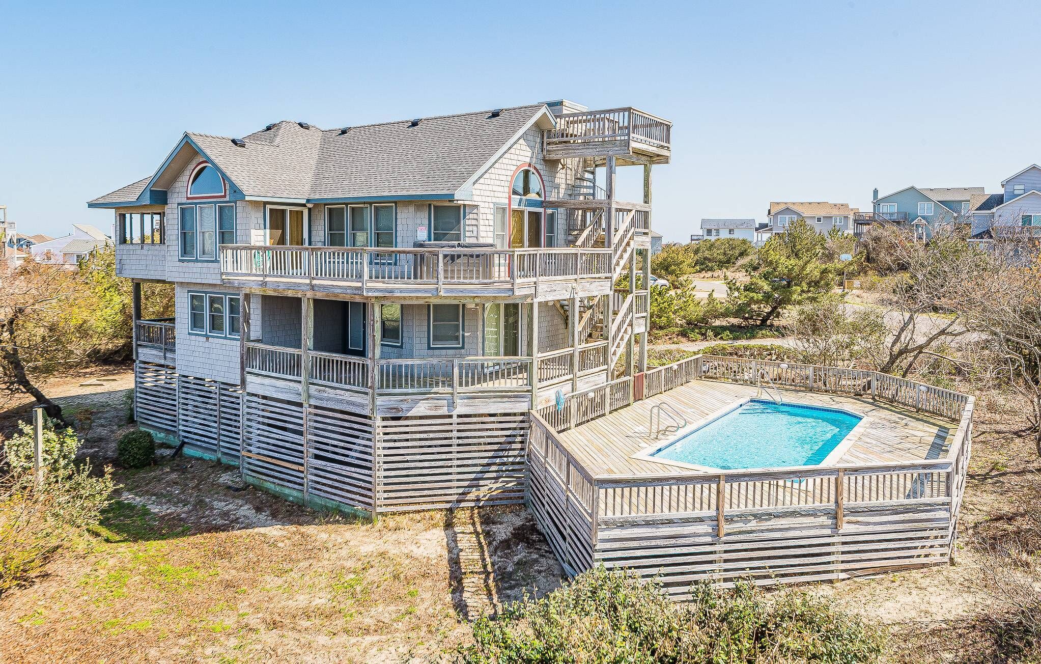 Une maison à plusieurs niveaux située en bord de mer, avec une piscine.