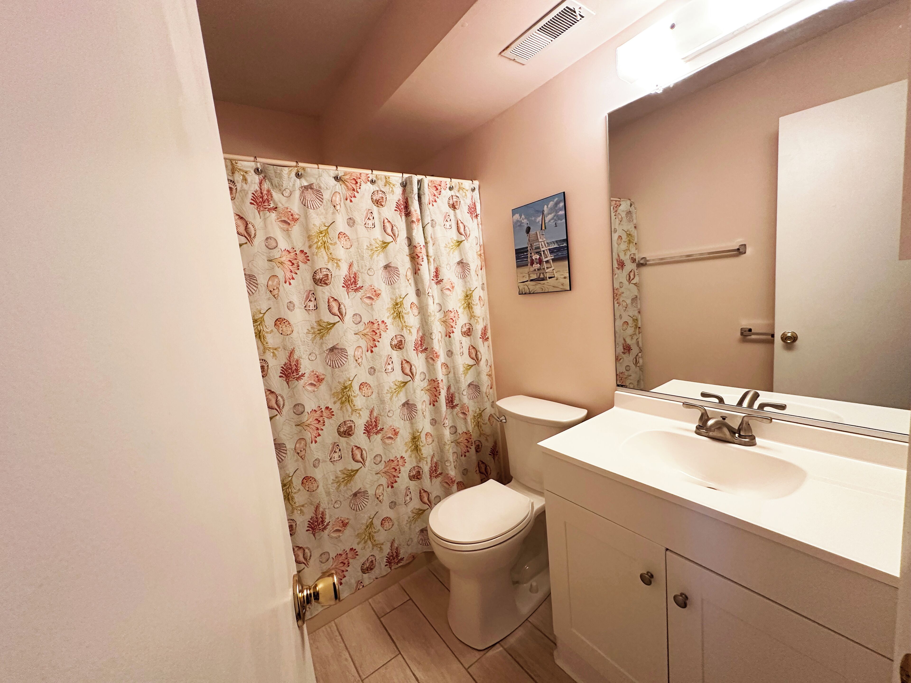 A bathroom with a toilet, sink, and shower curtain.