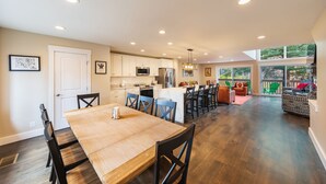 Una cocina amplia con comedor, ventanas grandes y vistas al exterior.
