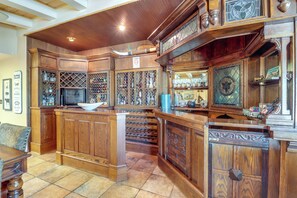 Angolo bar con mobili in legno, una cantina e una ciotola sul bancone.