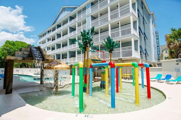A hotel with a water play area, including a slide and a pool.