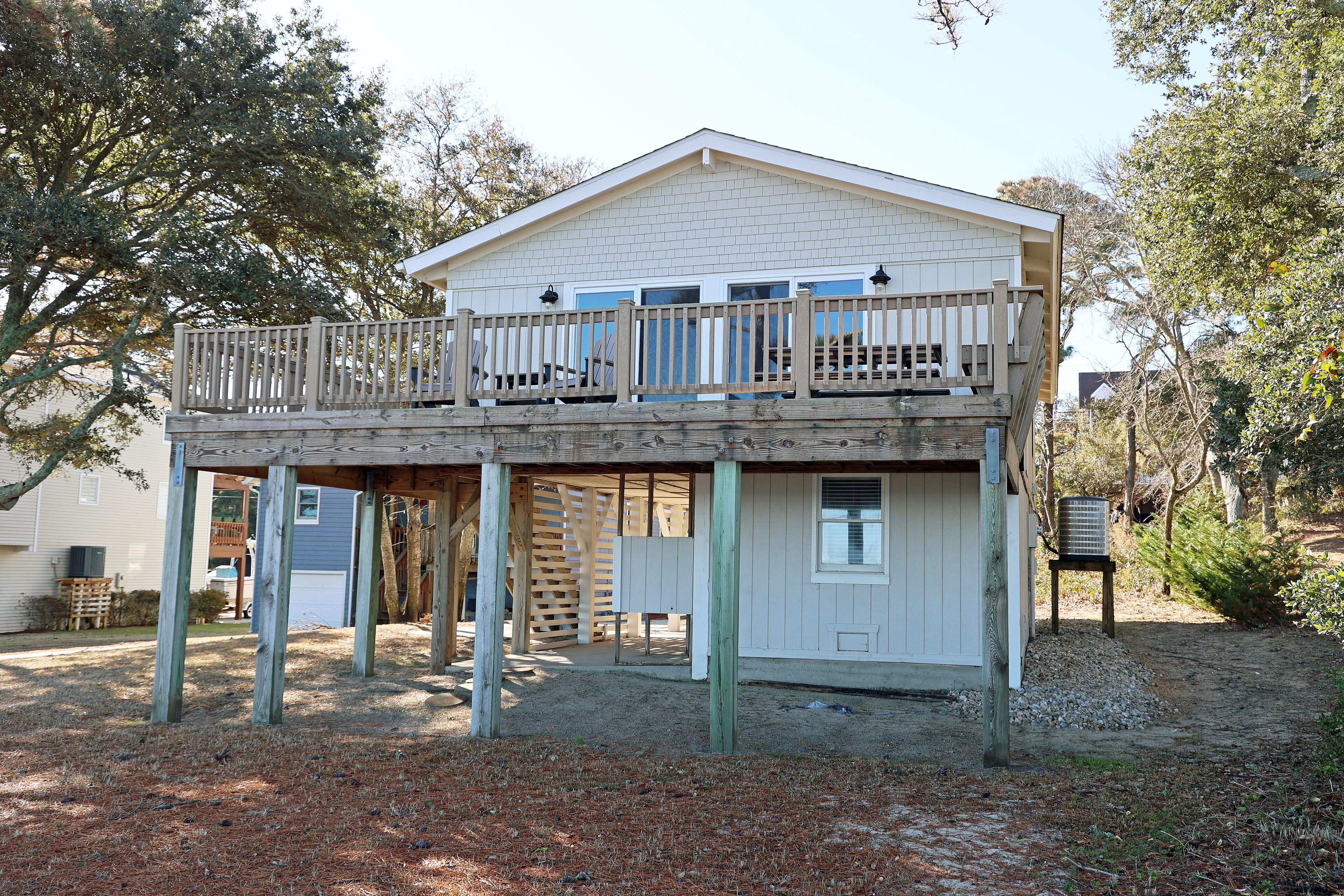A two-story house with a balcony, wooden deck, and a small shed.
