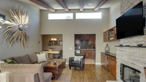 A spacious living area with a fireplace, a dining area, and a kitchen with stone accents. - Dtwn Palm Springs Condo: BBQ, Pool, Fire Pit, etc! (Palm Springs)