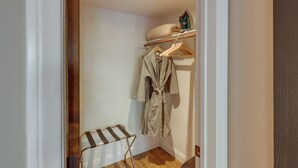 A small, narrow hallway with a wooden floor, a radiator, and a clothing rack with a robe hanging on it. - Dtwn Palm Springs Condo: BBQ, Pool, Fire Pit, etc! (Palm Springs)