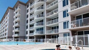 A multi-story hotel with balconies, a swimming pool, and a children's pool area. - IP 202: Gulf Dwelling -  Welcome to Your Beachfront Paradise! (Fort Walton Beach)