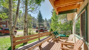 A wooden deck with a bench and chairs, surrounded by trees and a view of a road with vehicles. - Discount Available! Lake Tahoe Gem w/ Pool Table (South Lake Tahoe)