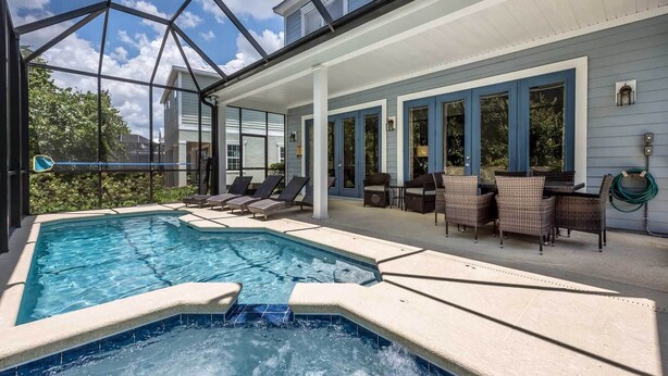 Piscina com espreguiçadeiras e um espaço coberto com varanda.