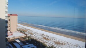 Un hôtel de grande hauteur donnant sur une plage et offrant une vue dégagée sur l’océan.