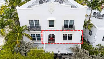 Un edificio blanco con entrada central, varias ventanas y balcones.