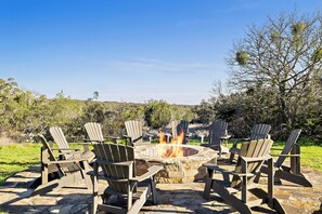 An outdoor seating area with Adirondack chairs and a fire pit.