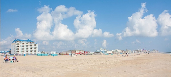 Une plage avec un grand hôtel et plusieurs bâtiments plus petits.